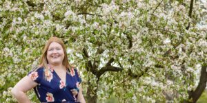 Hannah in front of apple blossom tree